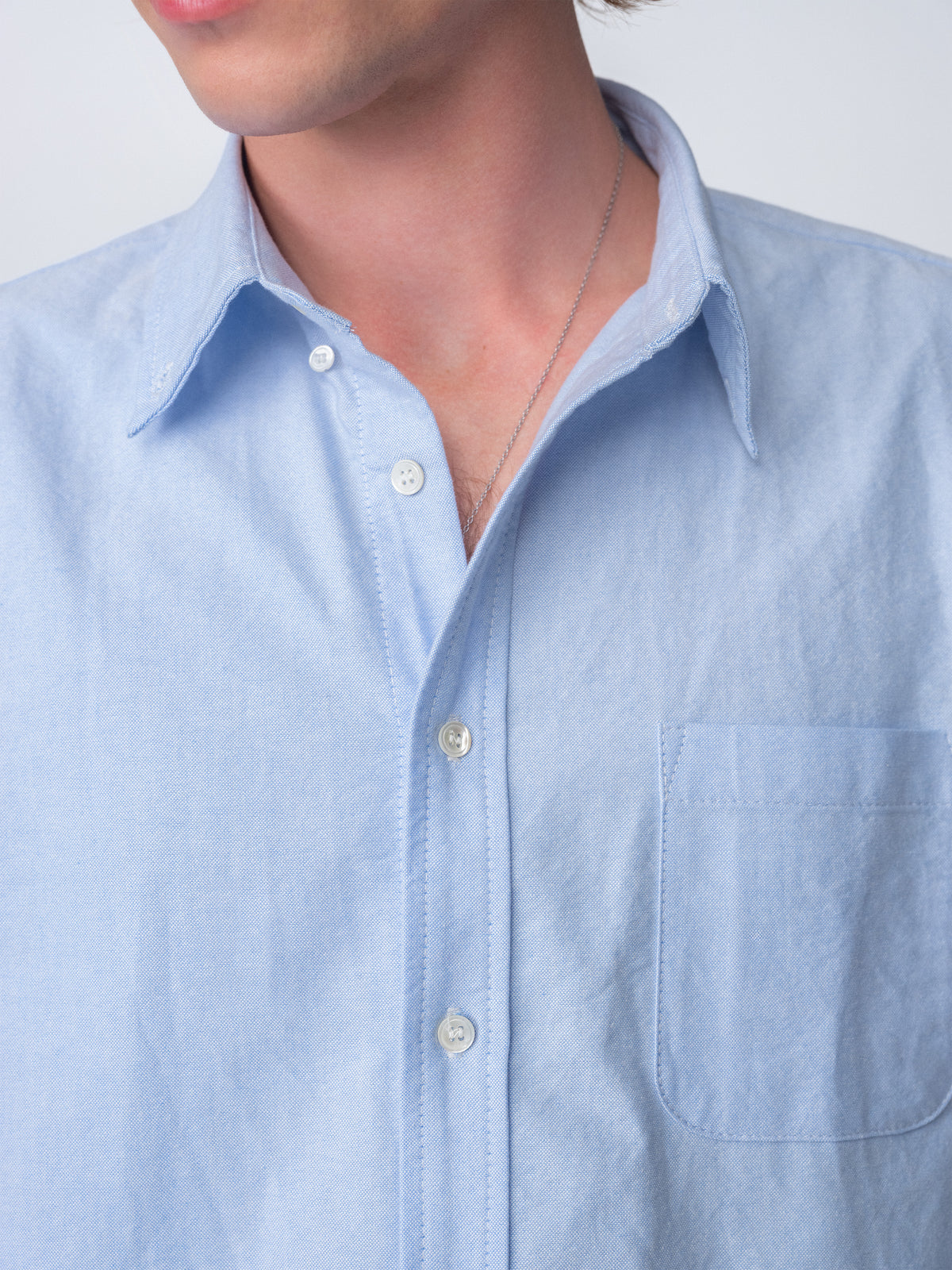 close up detail of guy wearing Hanover Essential Oxford Shirt in Blue on model