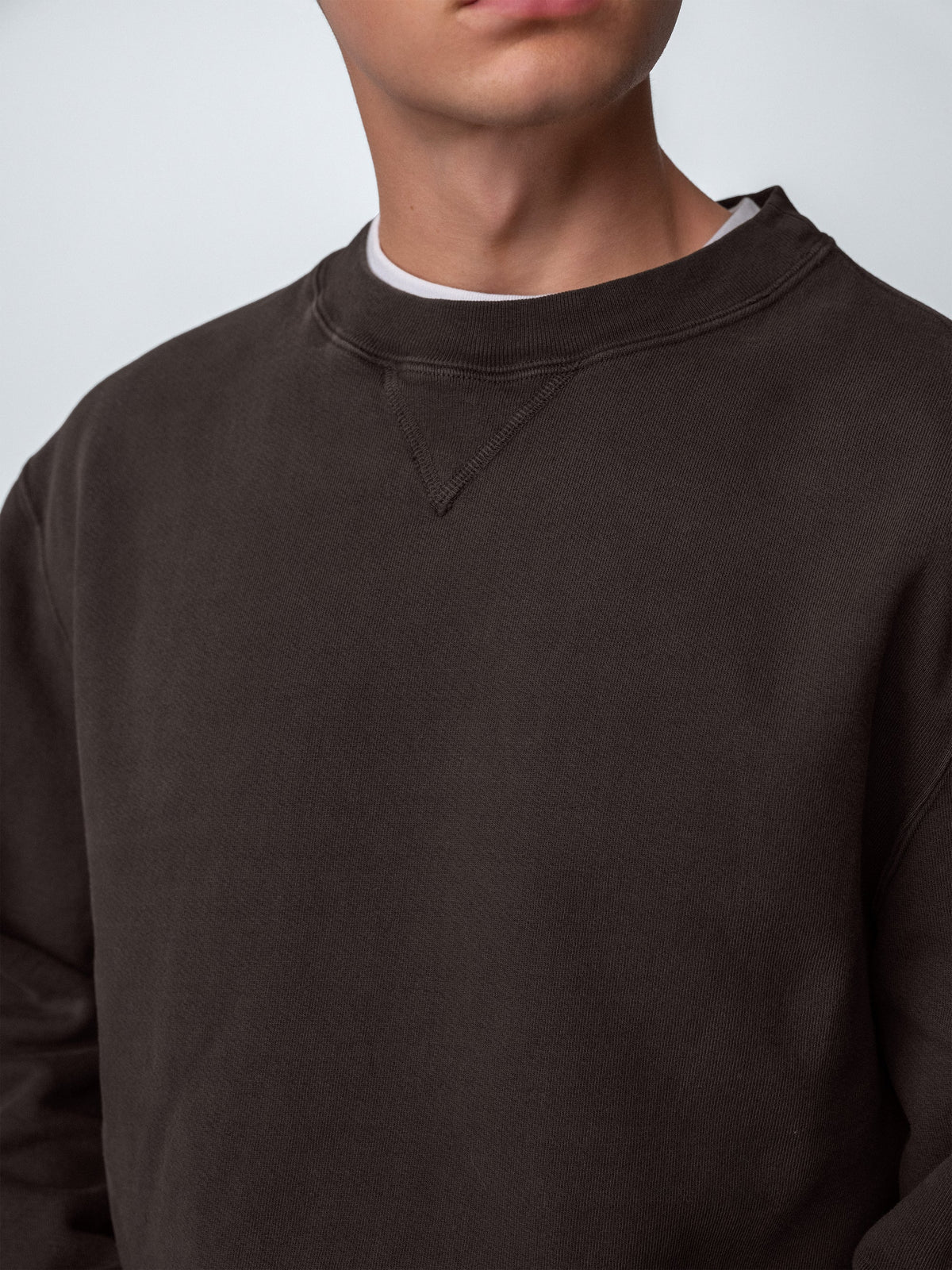 Detail of guy wearing Sunwashed Staple Crewneck in cacao