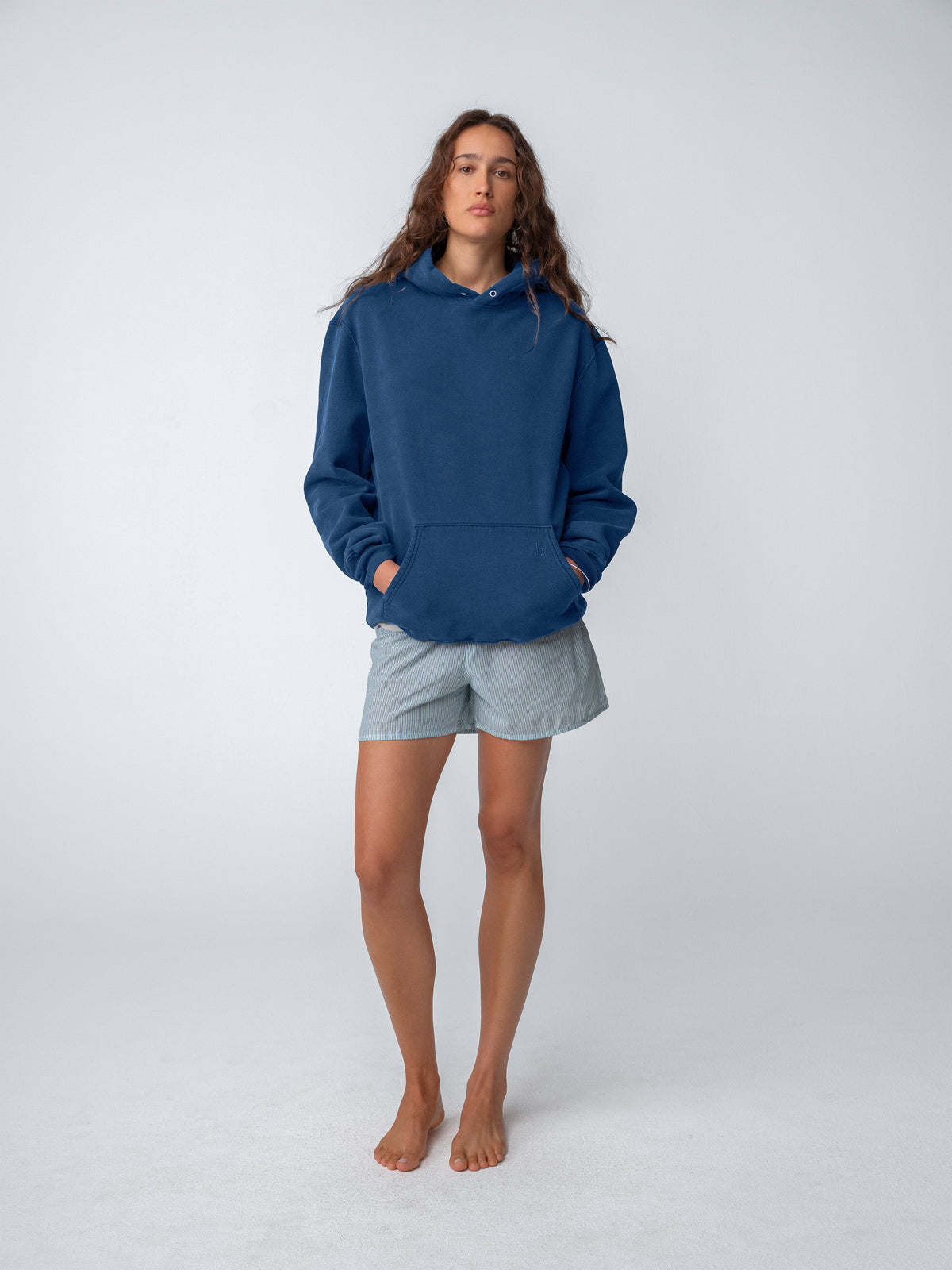 Woman model wearing Sunwashed Staple Hoodie in mid navy