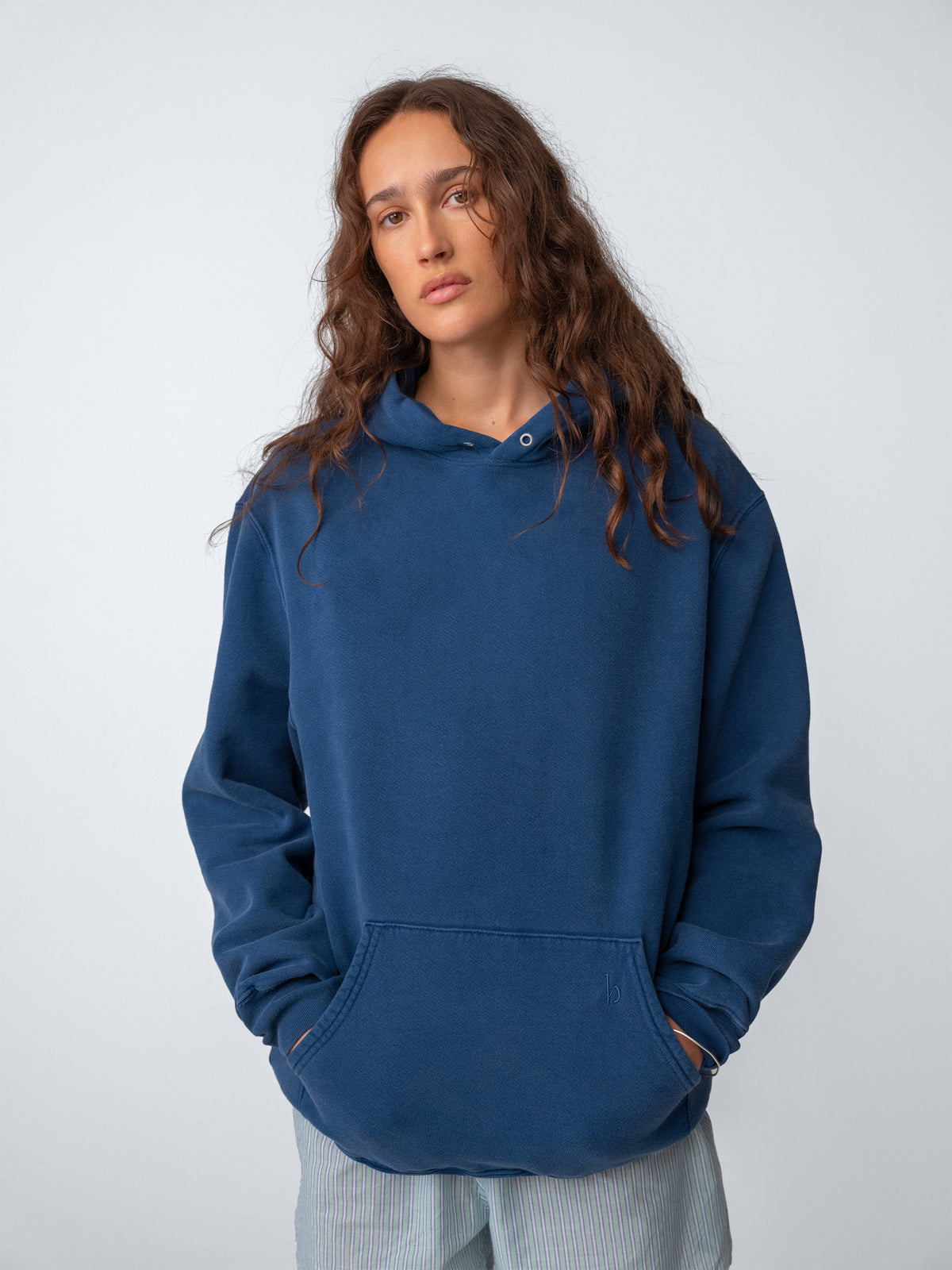 Woman model wearing Sunwashed Staple Hoodie in mid navy torso view
