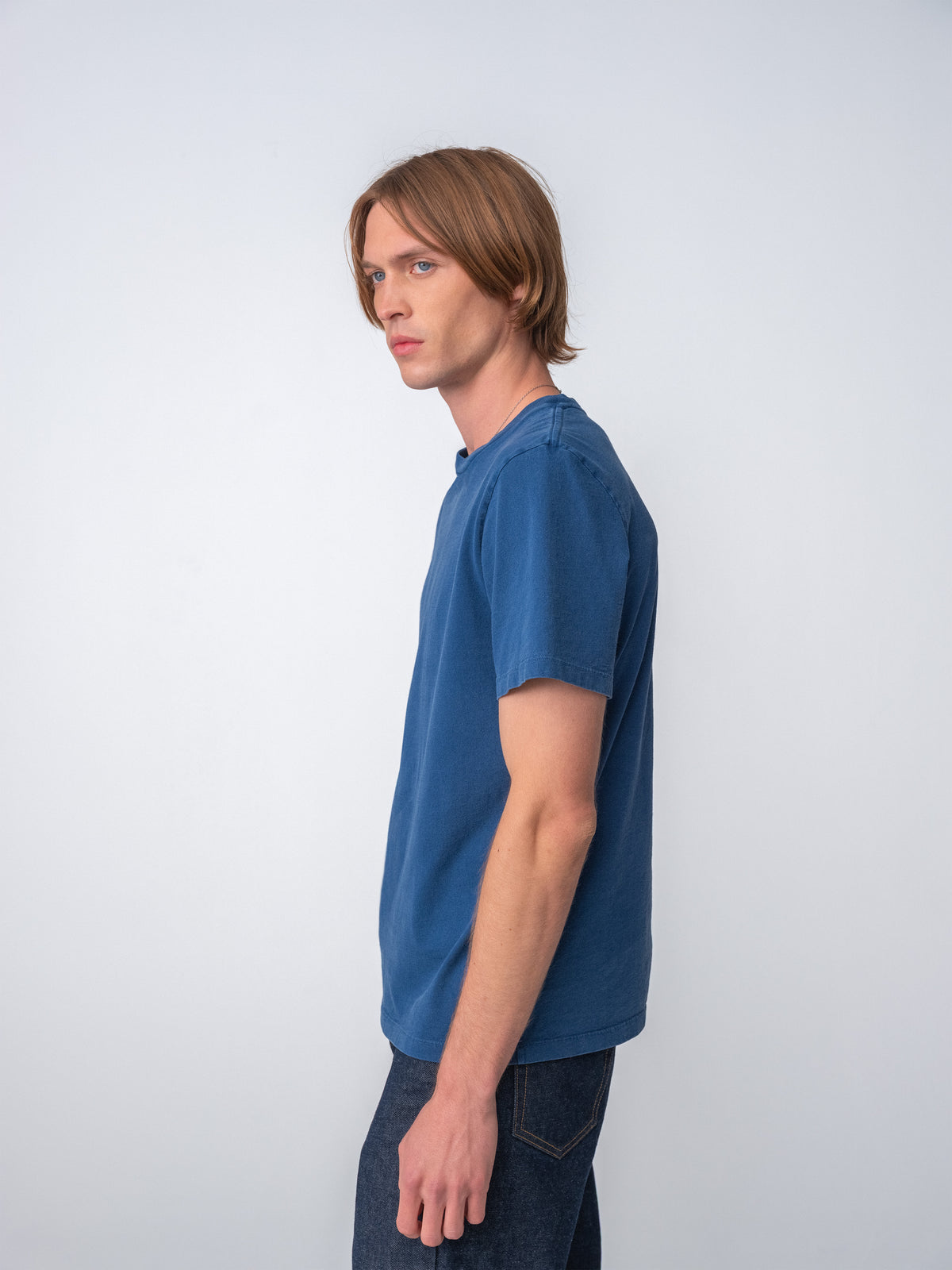 Model wearing Sunwashed Staple T-Shirt in mid navy side view