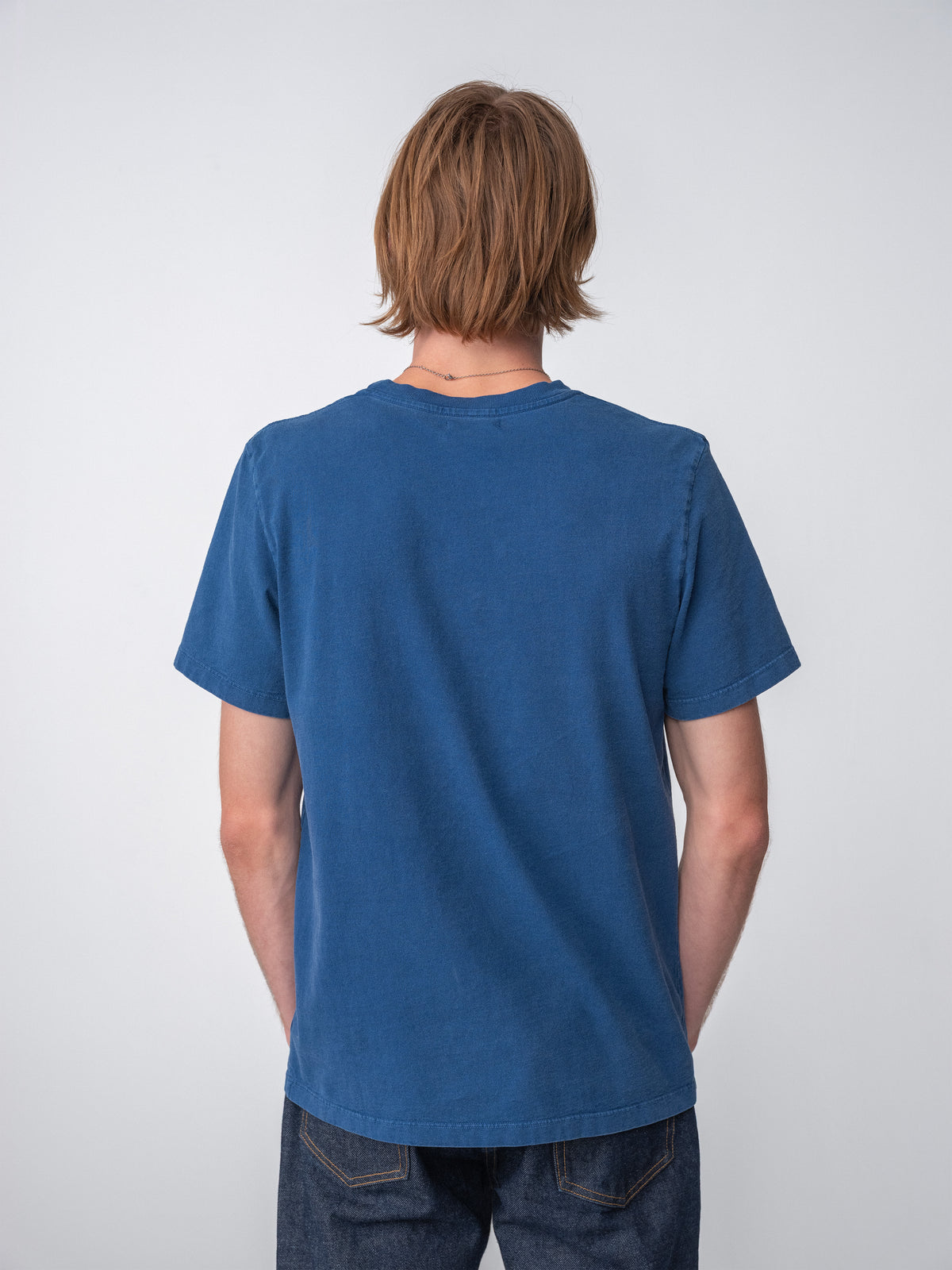 Model wearing Sunwashed Staple T-Shirt in mid navy back view