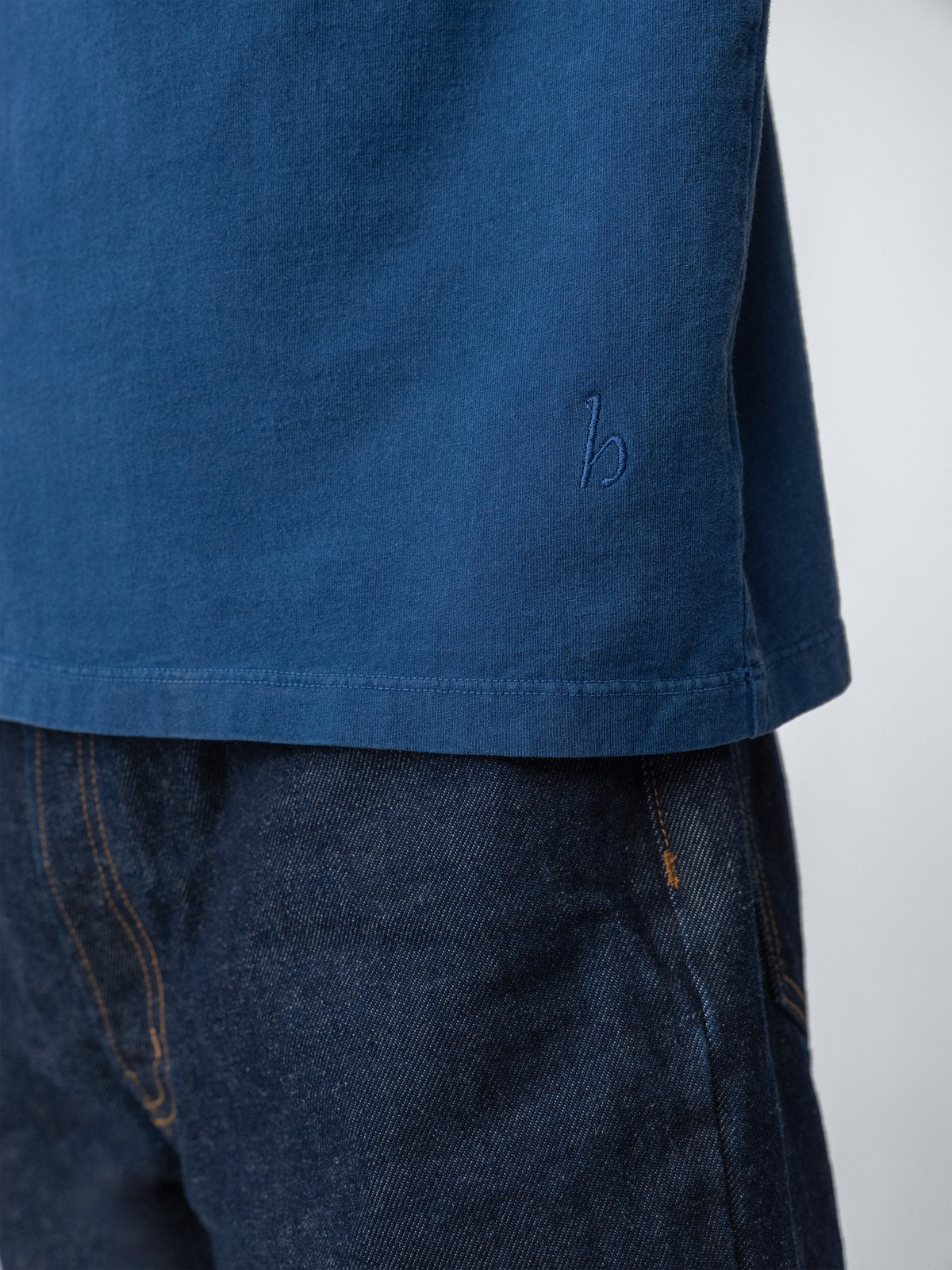 Model wearing Sunwashed Staple T-Shirt in mid navy detail close up view