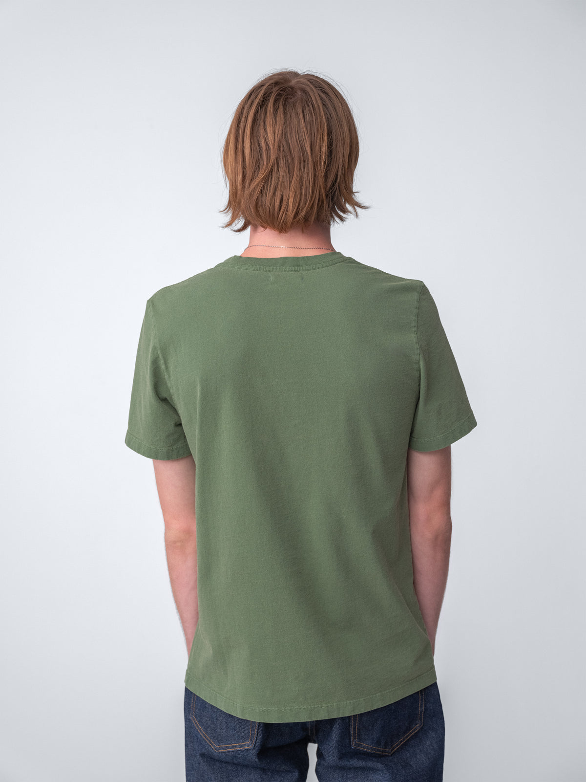 Model wearing Sunwashed Staple T-Shirt in spruce back view