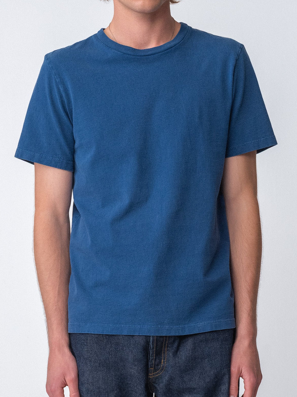 Model wearing Sunwashed Staple T-Shirt in mid navy full body view